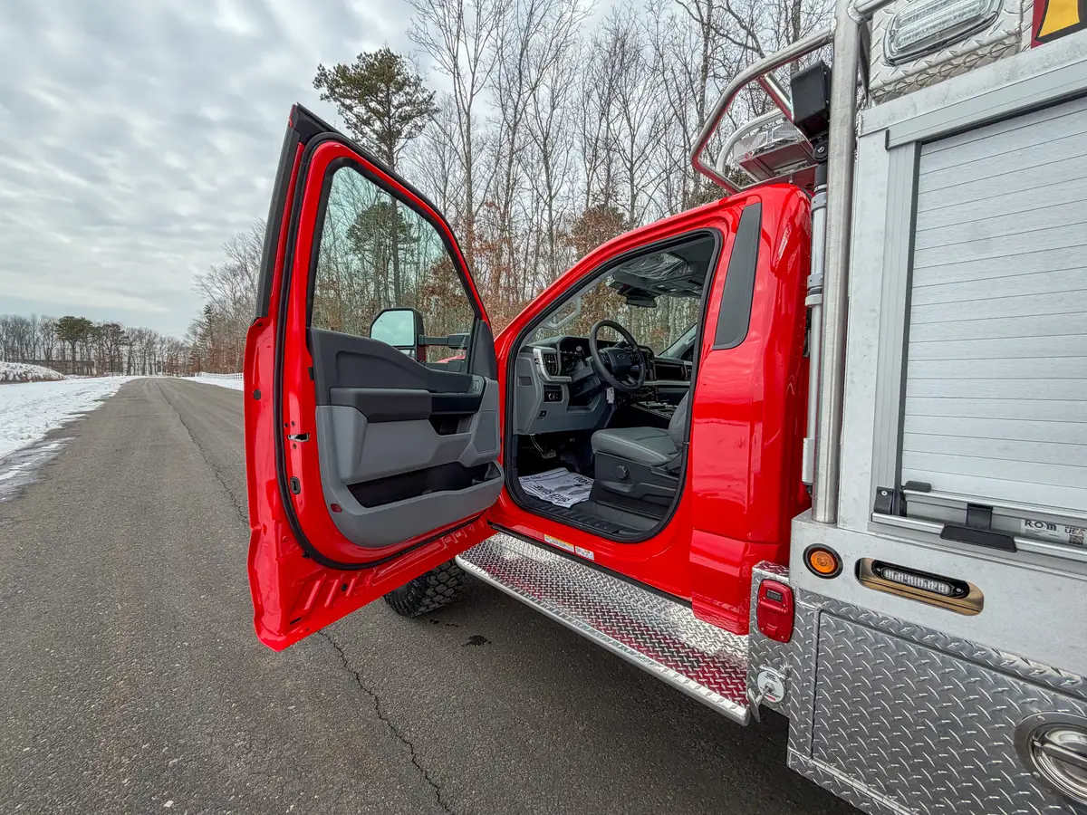 Open driver door showing step-in area and front seat.